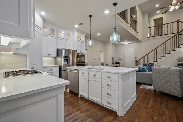 kitchen with a sink, dark wood-style flooring, appliances with stainless steel finishes, and open floor plan
