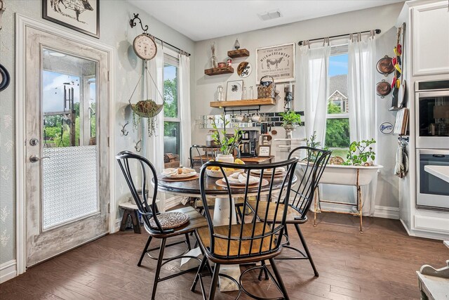 dining space with baseboards, visible vents, and hardwood / wood-style floors