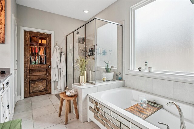 bathroom featuring tile patterned floors, recessed lighting, a shower stall, a spacious closet, and a bath
