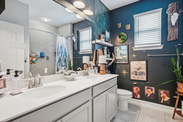 bathroom featuring a sink, a shower with curtain, tile patterned flooring, and toilet