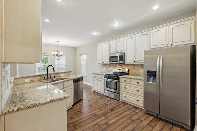 311 Wilson St, Whitesboro, TX 76273 - kitchen with a peninsula, a sink, stainless steel appliances, dark wood-style flooring, and decorative backsplash