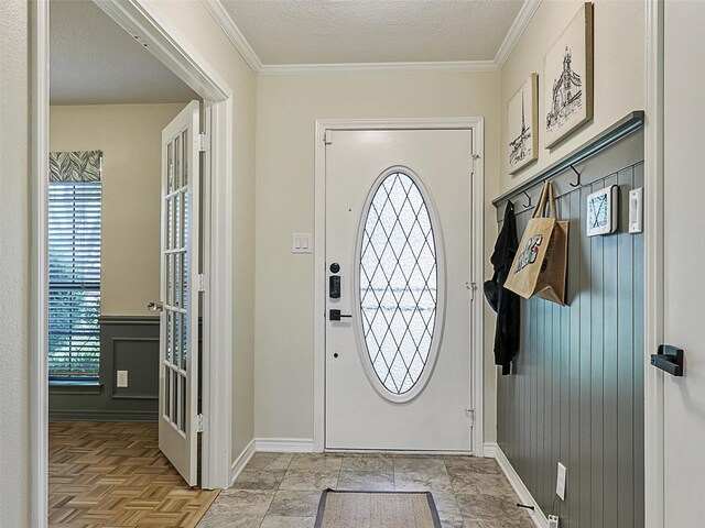 entryway with baseboards and ornamental molding