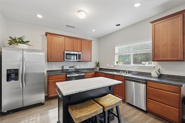 1612 Cambridge Dr, Providence Village, TX 76227 - kitchen featuring visible vents, a sink, light wood finished floors, and stainless steel appliances
