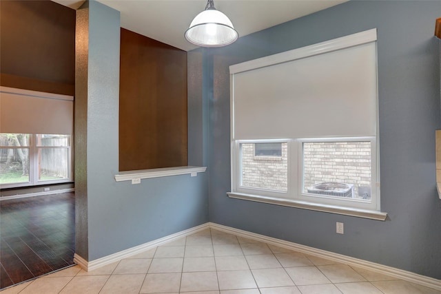 unfurnished room with baseboards and tile patterned flooring