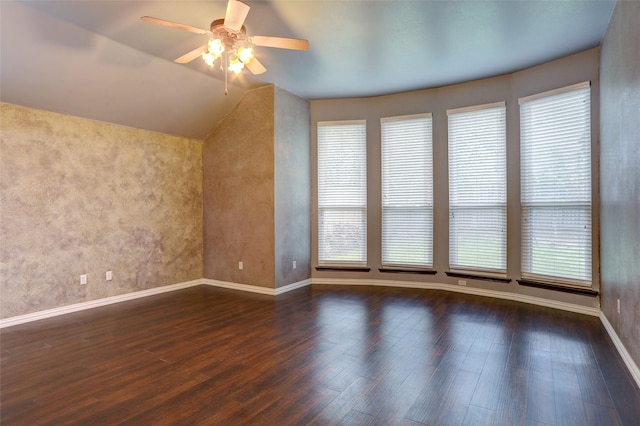 interior space with baseboards, a ceiling fan, wood finished floors, and a wealth of natural light