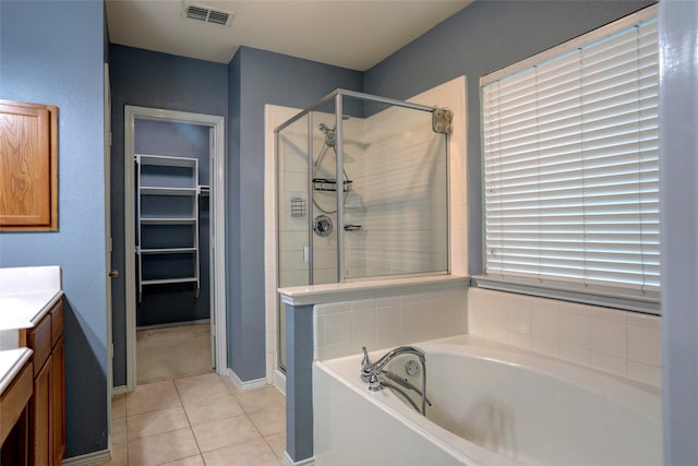 full bathroom featuring visible vents, vanity, tile patterned floors, a bath, and a shower stall