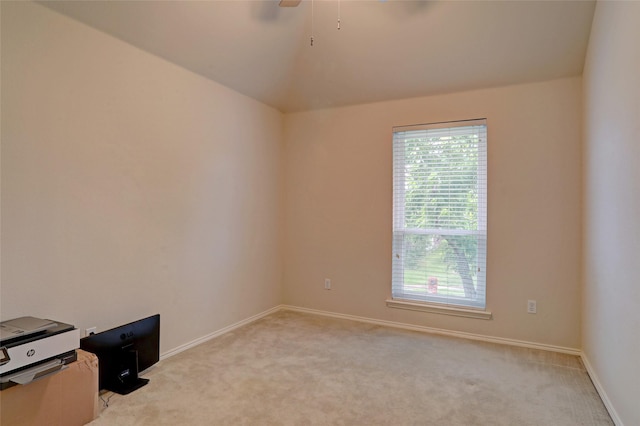 empty room featuring light colored carpet, baseboards, and lofted ceiling