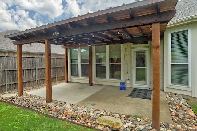 view of patio / terrace with ceiling fan and fence