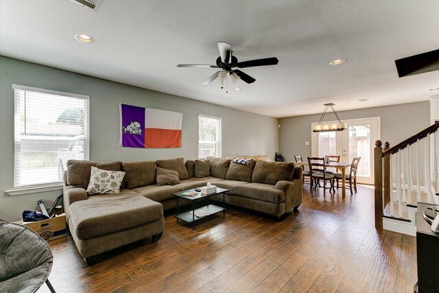 living room featuring recessed lighting, dark wood finished floors, ceiling fan with notable chandelier, and stairway