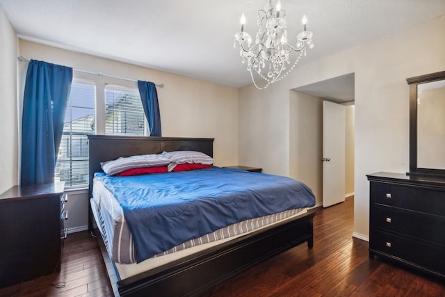 bedroom featuring an inviting chandelier, baseboards, and hardwood / wood-style floors