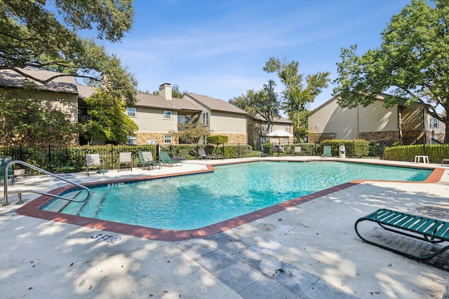 pool featuring fence, a residential view, and a patio area