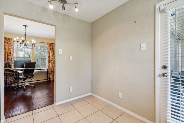office with baseboards, light tile patterned flooring, and a notable chandelier