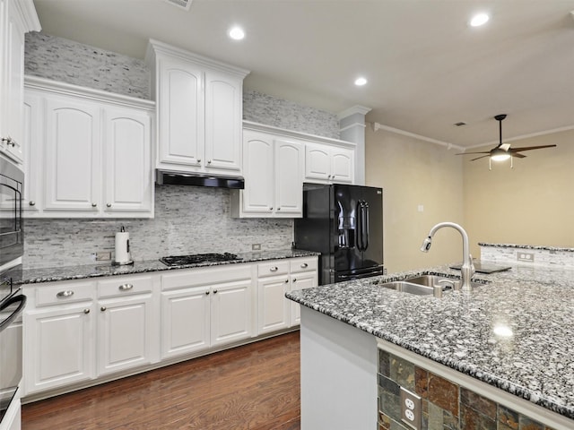 kitchen featuring black refrigerator with ice dispenser, ceiling fan, dark stone counters, gas stovetop, and a sink