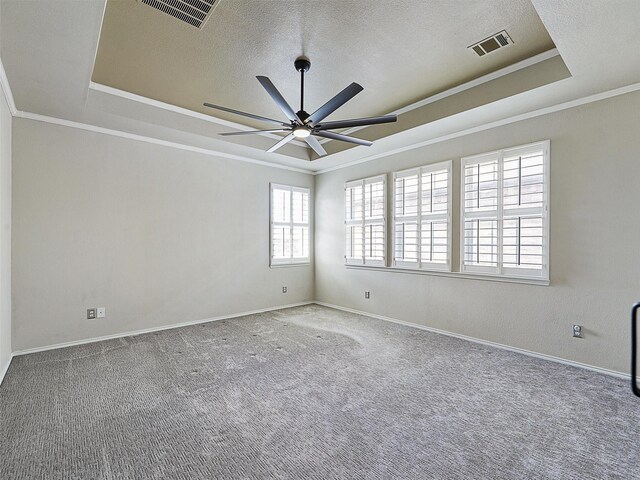 spare room with a raised ceiling, ornamental molding, and visible vents