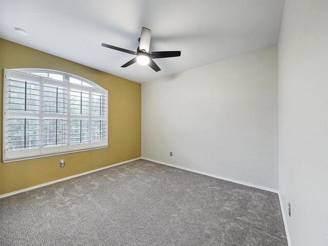 empty room with carpet flooring, a ceiling fan, and baseboards