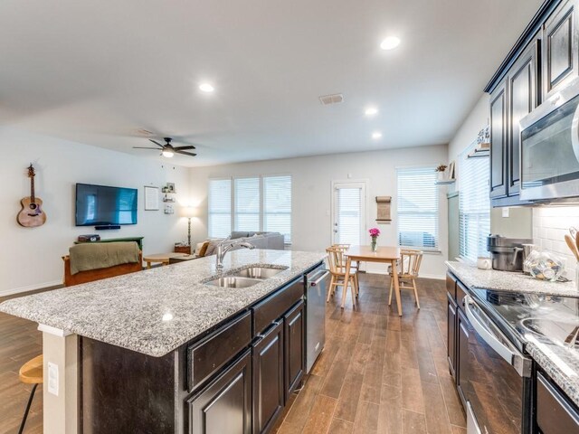 kitchen featuring ceiling fan, appliances with stainless steel finishes, a sink, wood finished floors, and visible vents