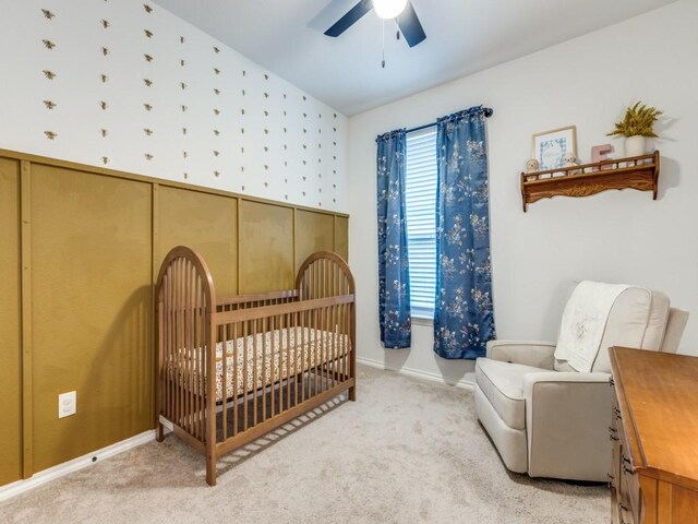 bedroom with a nursery area, carpet, a ceiling fan, baseboards, and vaulted ceiling