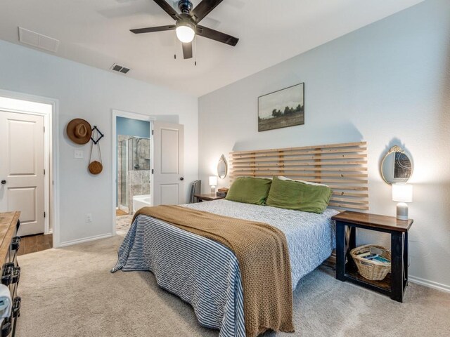 carpeted bedroom featuring baseboards, connected bathroom, and visible vents
