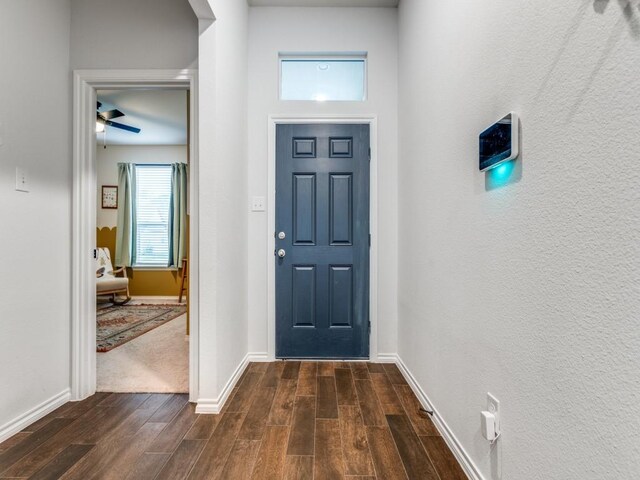 foyer with baseboards, dark wood-style floors, and ceiling fan