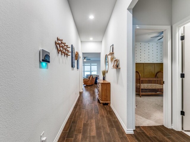 corridor featuring dark wood-type flooring, recessed lighting, and baseboards