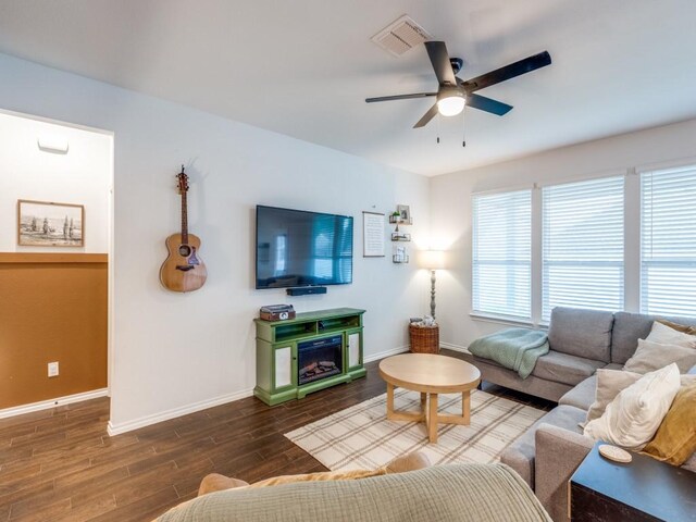living area with a ceiling fan, baseboards, visible vents, and wood finished floors