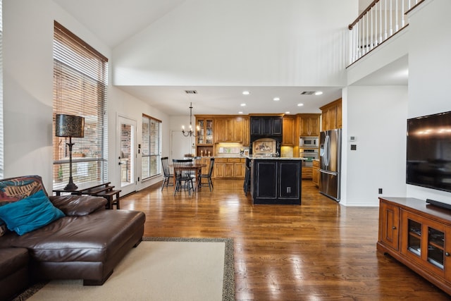 living area with recessed lighting, high vaulted ceiling, dark wood-style flooring, and a chandelier