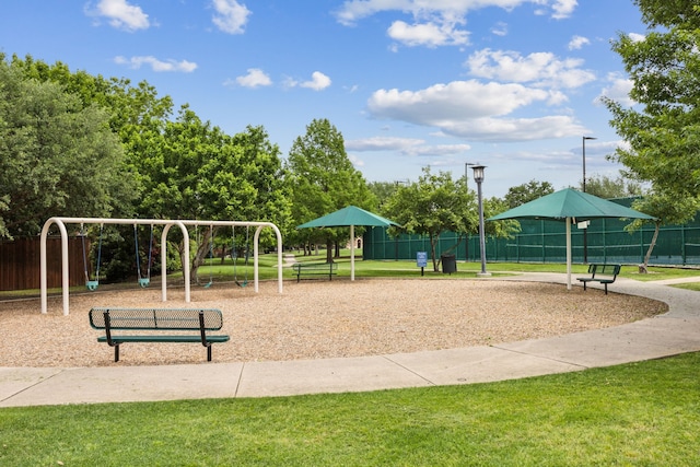 view of community with a yard, fence, and playground community