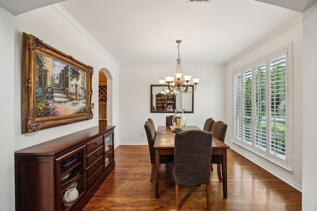 dining space featuring dark wood-style flooring, crown molding, arched walkways, baseboards, and a chandelier