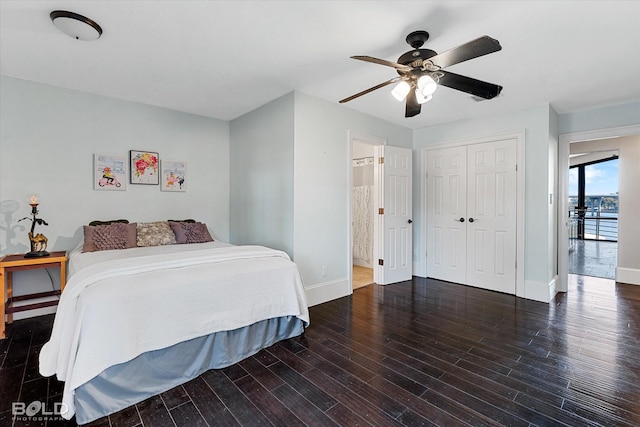 bedroom featuring a closet, wood finished floors, baseboards, connected bathroom, and a ceiling fan