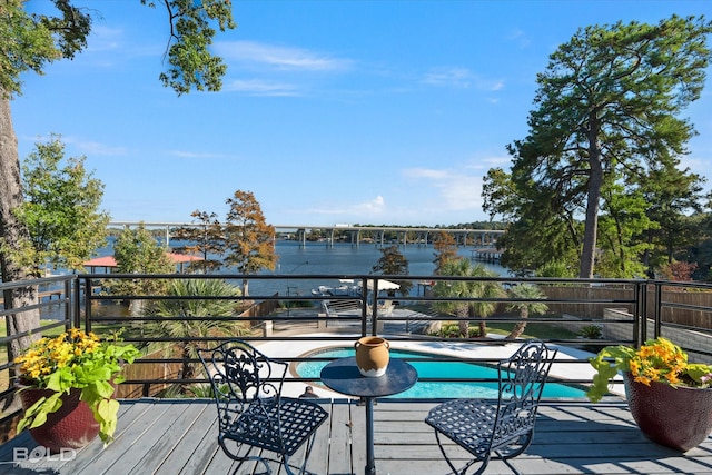 wooden deck featuring a water view and a fenced in pool