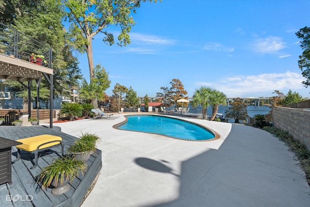 outdoor pool with fence and a patio area