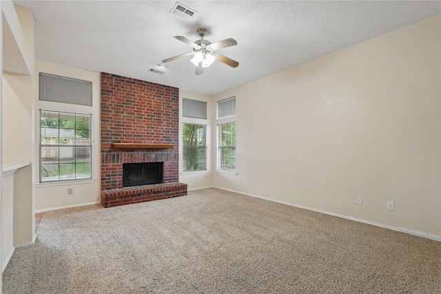 unfurnished living room with carpet floors, plenty of natural light, a brick fireplace, and visible vents