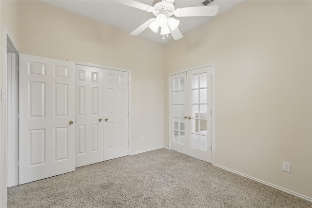 unfurnished bedroom featuring a closet, carpet flooring, baseboards, and a ceiling fan