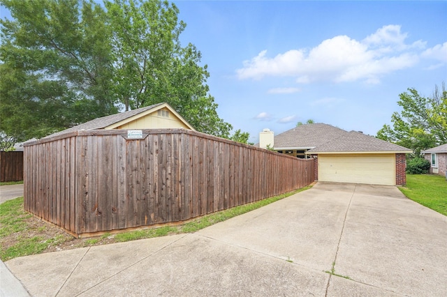 view of property exterior with brick siding, a garage, fence, and driveway