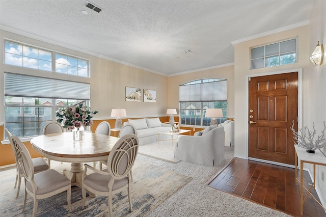 dining space with plenty of natural light, crown molding, and hardwood / wood-style flooring