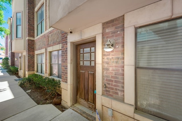 doorway to property featuring brick siding