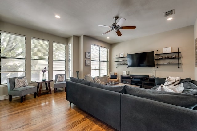 living room featuring a ceiling fan, visible vents, recessed lighting, and light wood finished floors