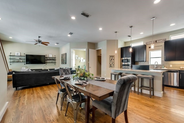 dining space with visible vents, a ceiling fan, and light wood-type flooring
