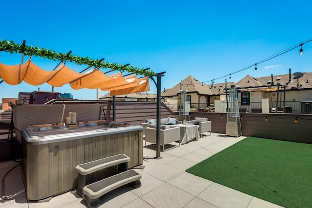 view of patio / terrace with a hot tub and fence