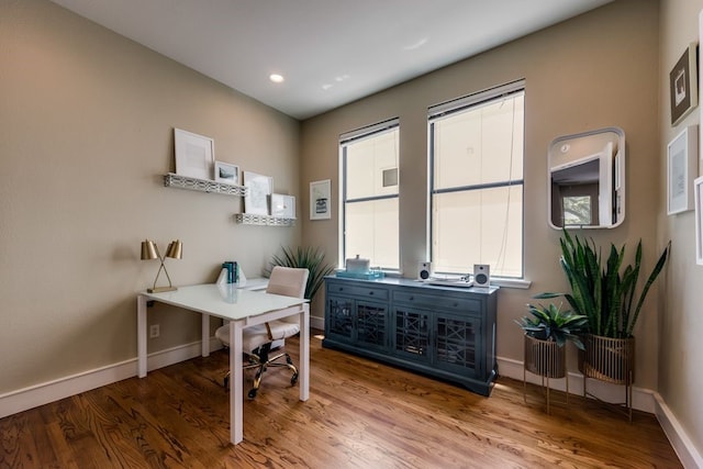 home office with baseboards, a wealth of natural light, and wood finished floors