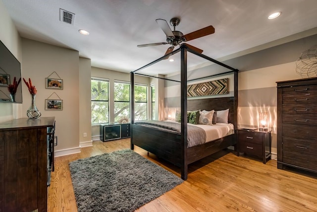 bedroom with baseboards, light wood finished floors, recessed lighting, and visible vents