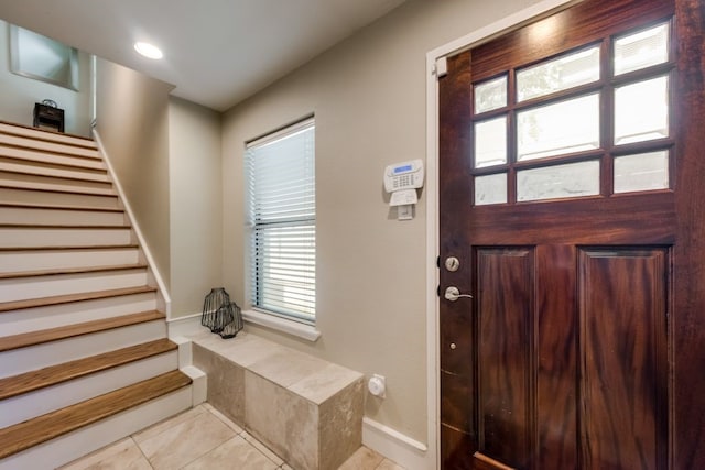 entryway featuring light tile patterned flooring and stairway