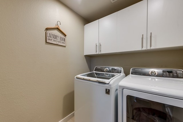washroom with cabinet space and washer and clothes dryer