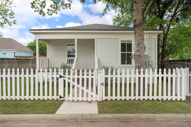 bungalow with a gate, a fenced front yard, roof with shingles, and covered porch