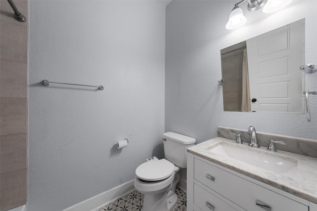 bathroom with vanity, baseboards, and toilet