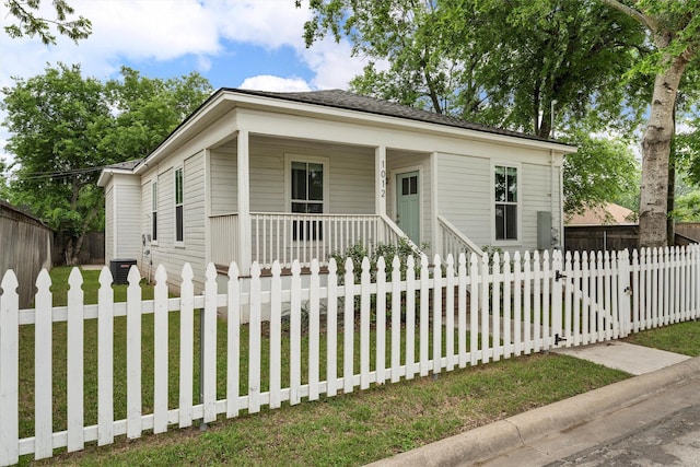 view of front of property with a porch, a fenced front yard, a gate, and a front lawn