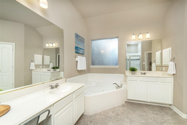bathroom featuring a shower stall, two vanities, a tub with jets, and a sink