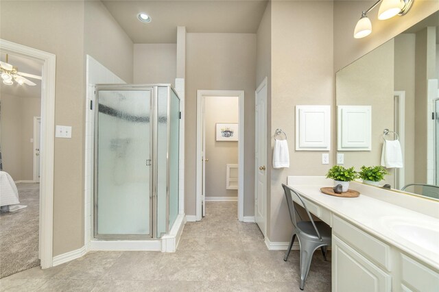 full bathroom with vanity, baseboards, ceiling fan, and a stall shower