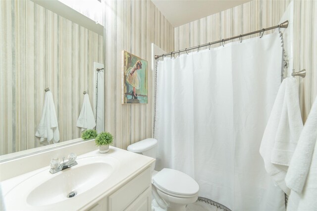bathroom featuring vanity, a shower with shower curtain, toilet, and wallpapered walls