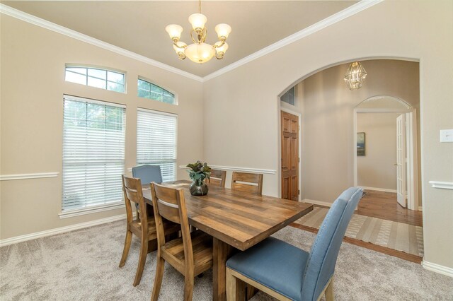 dining space featuring crown molding, arched walkways, baseboards, and a chandelier